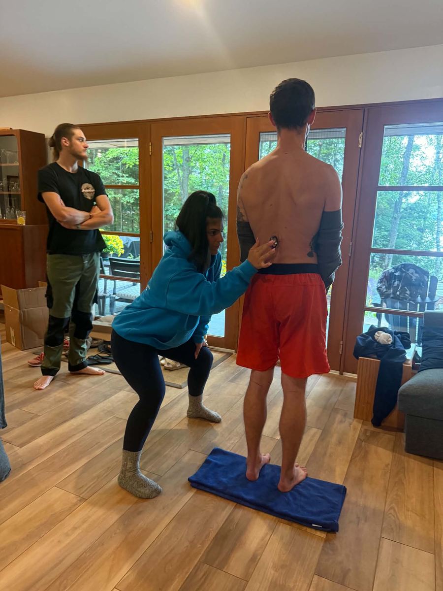 A practitioner performing a hands-on postural assessment