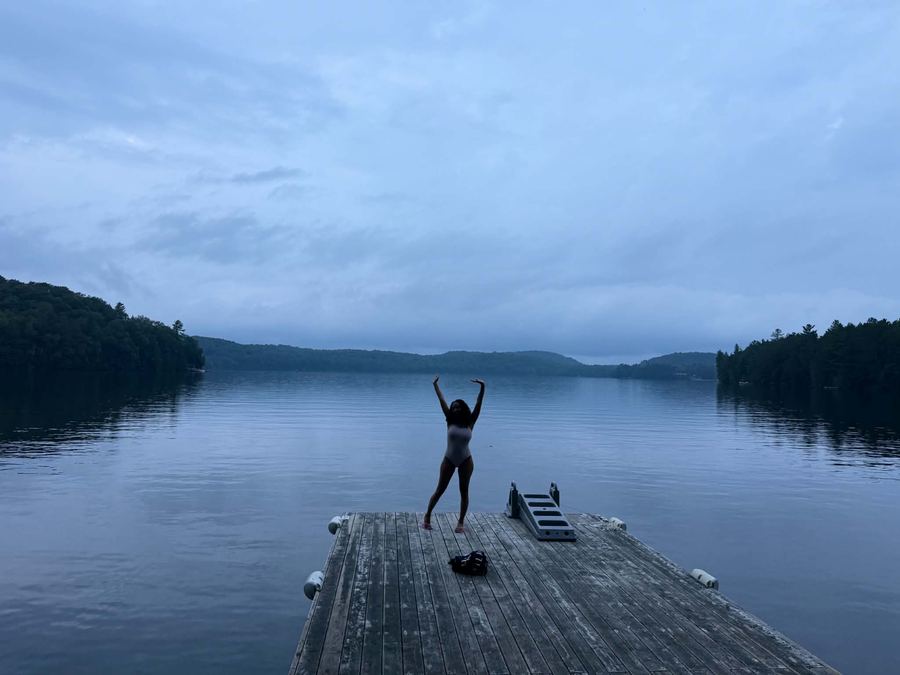 A guest stretching on the dock at first light before a swim
