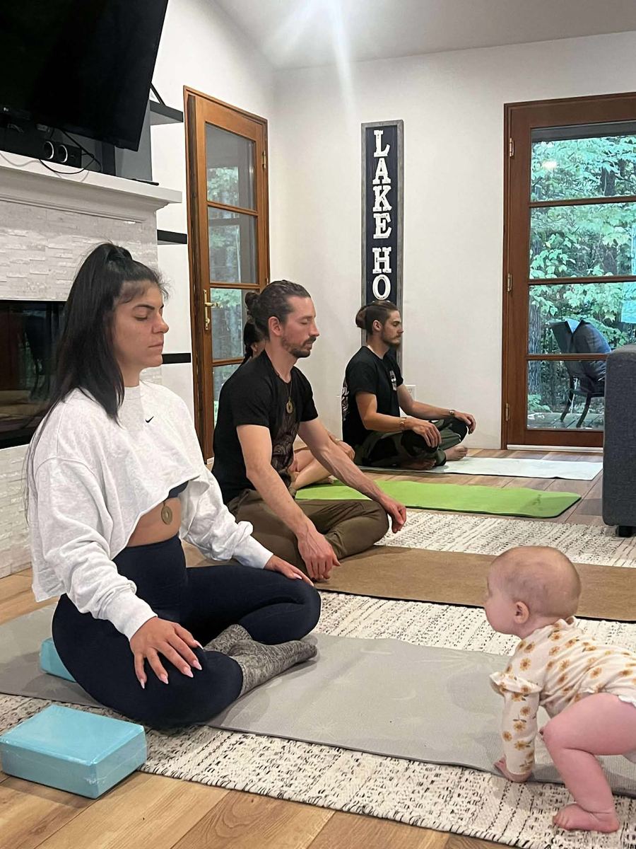 Practitioners meditating together on yoga mats in the lake house